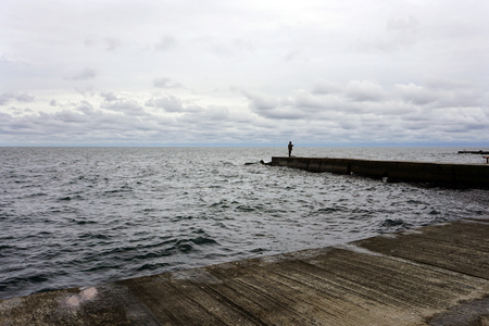fisherman at the sea pierce landscape with a lot of cloudsの写真素材