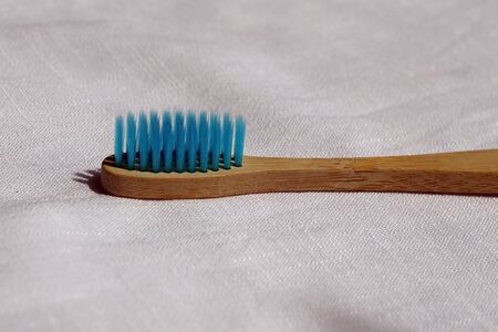 Close up of the Eco-friendly blue bamboo toothbrush on a white linen background. Natural organic bathroom beauty product concept. copy spaceの写真素材