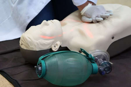 Chest compressions by a student on a simulation dummy during basic life support with an automatic external defibrillator. Simulation training scenarioの写真素材