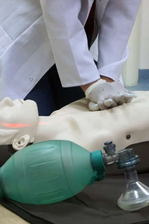Chest compressions on a simulation dummy during basic life support with an automatic external defibrillator. Simulation training scenario. Verticalの写真素材