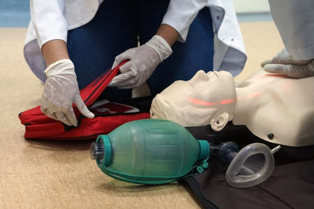 Chest compressions by a student on a simulation dummy during basic life support with an automatic external defibrillator. Simulation training scenarioの写真素材