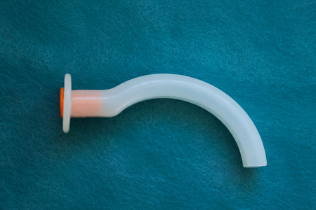 An oropharyngeal airway (OPA) tube is used in emergency medicine and anesthesia to maintain airway patency in unconscious patients. Medical equipment for airway managementの写真素材