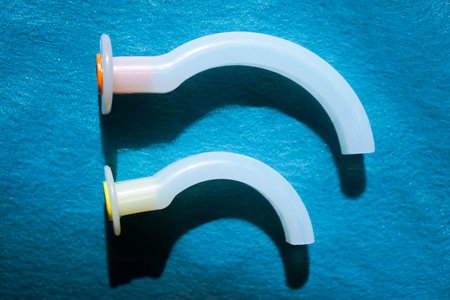 An oropharyngeal airway (OPA) tube is used in emergency medicine and anesthesia to maintain airway patency in unconscious patients. Medical equipment for airway managementの写真素材
