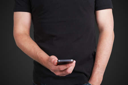man in black t-shirt with cellular phone