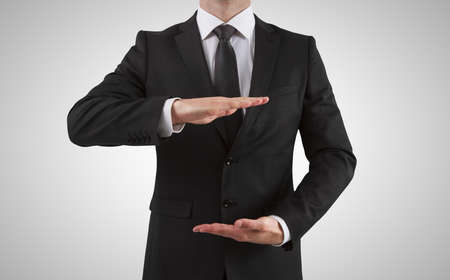 Businessman showing something on a gray backgroundの写真素材