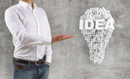 man shows to idea symbol  on wall backgroundの写真素材