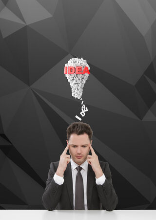 young businessman sitting on table and thinkingの写真素材