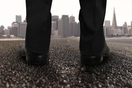 pair of feet standing on road and modern cityの写真素材