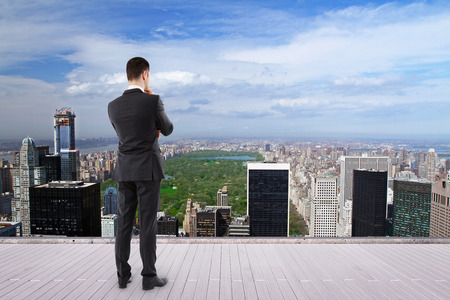 man standing on roof and looking at new yorkの写真素材