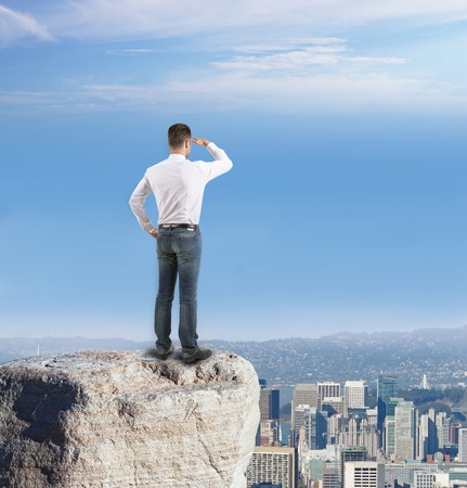 businessman looking at city in distanceの写真素材