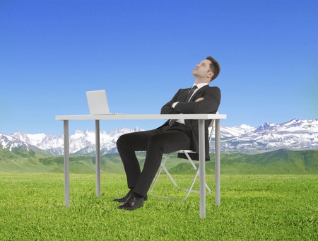 businessman sitting and looking to skyの写真素材