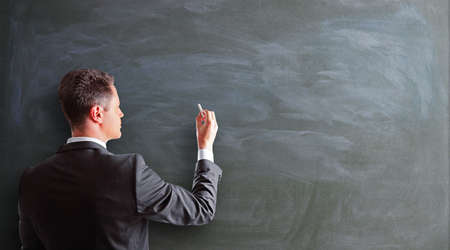 businessman drawing on a blackboard, close upの写真素材