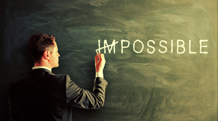 businessman drawing impossible text on a chalk boardの写真素材