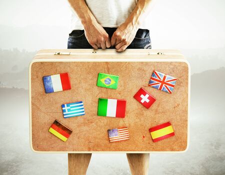 man holding leather  travel bag with flags