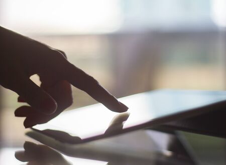 woman hand pushing on a digital tablet, shallow depth of fieldの写真素材