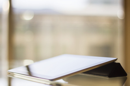Digital tablet on a glass table at sunset