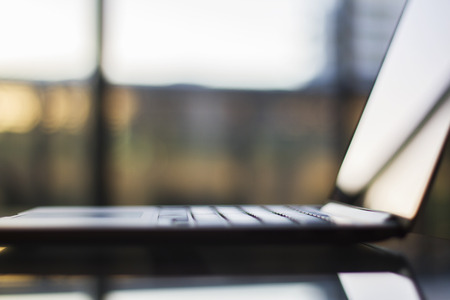 a glass table with a laptop, shallow depth of fieldの写真素材