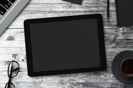 Blank black digital tablet on a wooden tableの写真素材