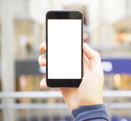 hand with empty cell phone on blurred backgroundの写真素材
