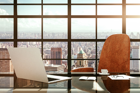 Modern workplace with a laptop and office accessories at sunriseの写真素材