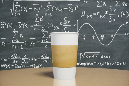 Blank cup of coffee on the table and the solution of equation on blackboardの写真素材