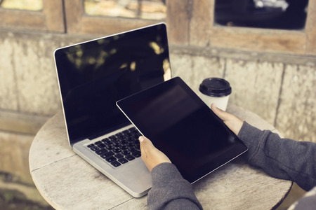 Woman with digital tablet and laptop outdoorsの写真素材