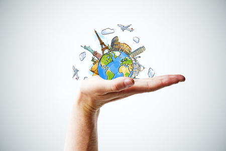 Hand holding a globe with landmarksの写真素材