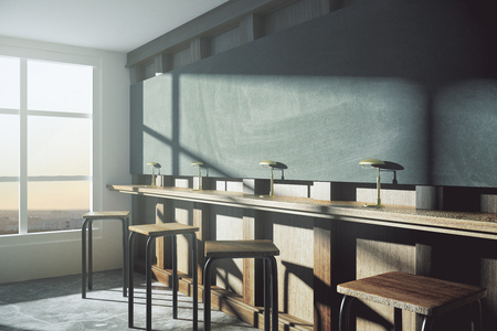 Modern college classroom with blank blackboard and window in floor at sunriseの写真素材