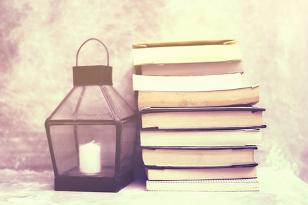 Pile of old books with vintage candlestickの写真素材