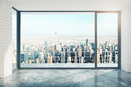 Empty loft room with big window in floor and city viewの写真素材