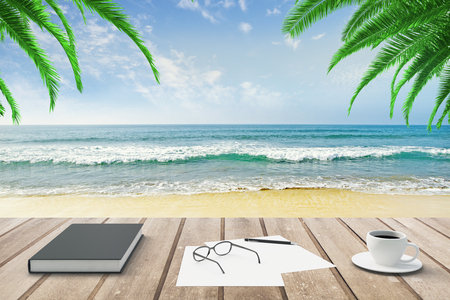 Diary, blank papers and cup of coffee on wooden bench at beach backgroundの写真素材