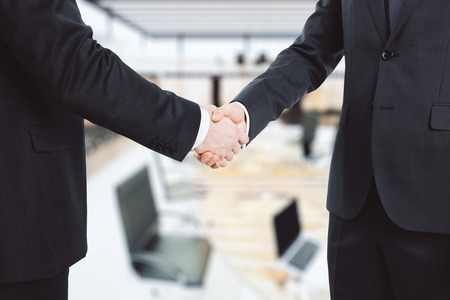 Business partners shake hands in the officeの写真素材