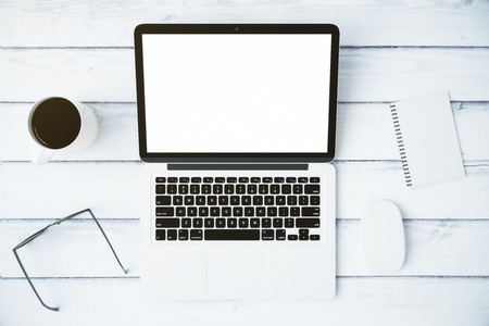 Top view of blank laptop and cup of coffee and accessories on a white wooden table, mock upの写真素材