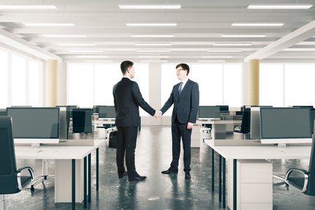 Businessmen shake hands ini modern open space officeの写真素材