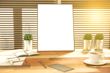 Blank picture frame on a wooden desk at sunsetの写真素材
