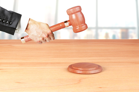 Man hand with gavel on wooden tableの写真素材