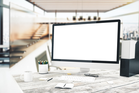 Blank monitor on wooden desktop with sunlit office in the background. Mock up, 3D Renderの写真素材