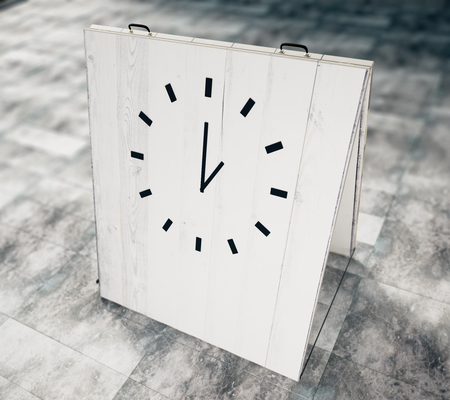 Clock on white wooden chalkboard on concrete floorの写真素材
