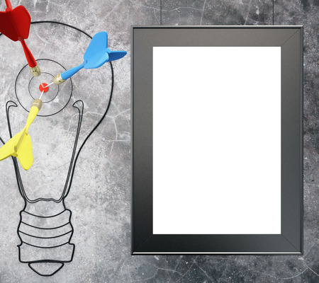 Goal concept with light bulb, darts and blank picture frame on concrete wall. Mock up, 3D Renderの写真素材