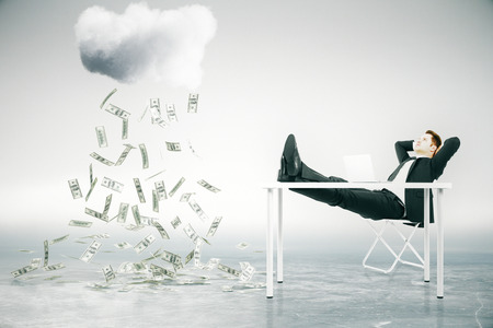 Financial growth concept with businessman sitting at table with feet up and looking at abstract money rain. 3D Renderingの写真素材