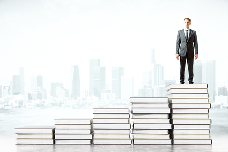 Businessman standing on book stacks on foggy city background. 3D Renderingの写真素材