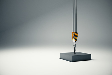 Black block suspended on crane hook going into hole. 3D Renderingの写真素材