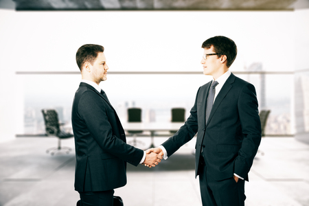 Businesspeople shaking hands in blurry conference room interiorの写真素材
