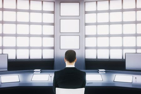Businessman sitting in security room interior with blank screens. Mock up, 3D Renderingの写真素材