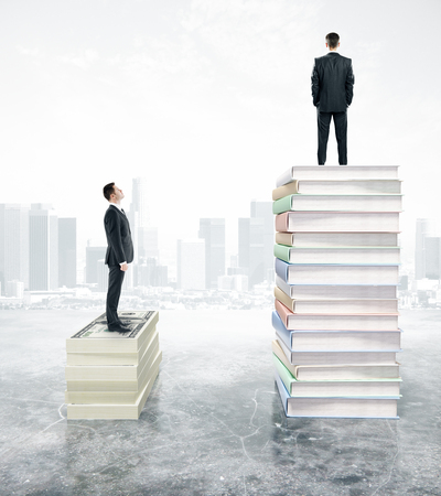 Two businessman standing on stack of books and looking to city view. 3D Renderingの写真素材