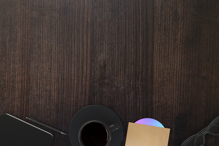 Top view of wooden office desktop with coffee cup, cd, pen, smartphone and glasses. Mock up, 3D Renderingの写真素材