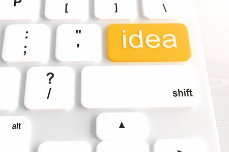 Closeup of white keyboard with orange idea button on light desktop. 3D Renderingの写真素材