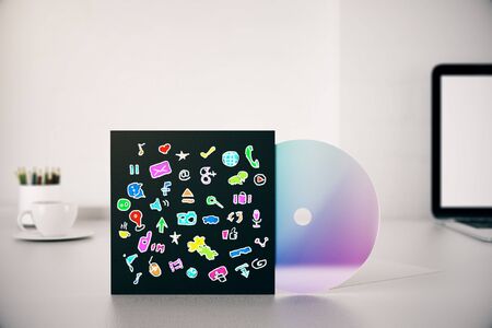 CD cover with colorful social media related icons sketch on white desktop with laptop, coffee cup and other items. Communication conceptの写真素材