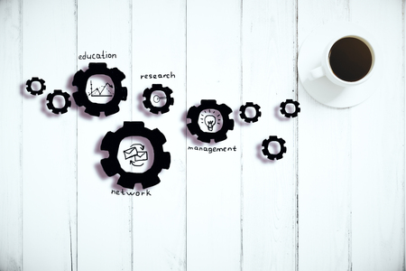 White wooden plank surface with abstract cogwheel sketch and coffee cupの写真素材