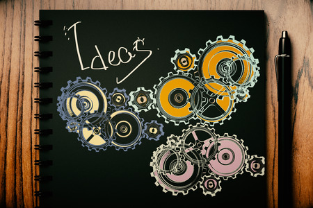 Top view of black spiral notepad with gears sketch and pen on wooden desktop. 3D Rendering. Ideas conceptの写真素材